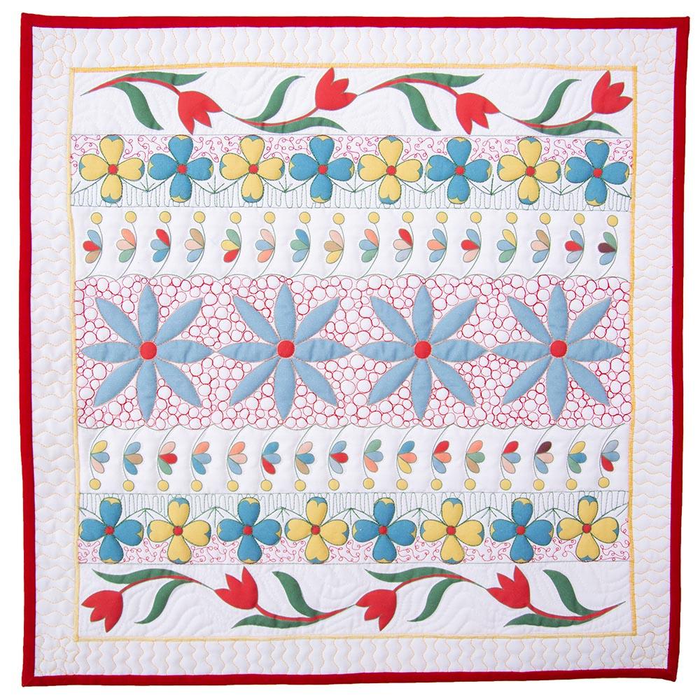 floral printed fabric panel with decorative free motion quillting designs in white green and red thread