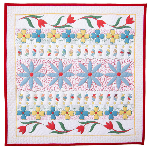 floral printed fabric panel with decorative free motion quillting designs in white green and red thread