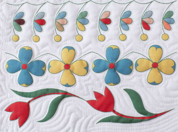 free motion quilting with white thread on white back ground fabric surrounding  colourful flowers